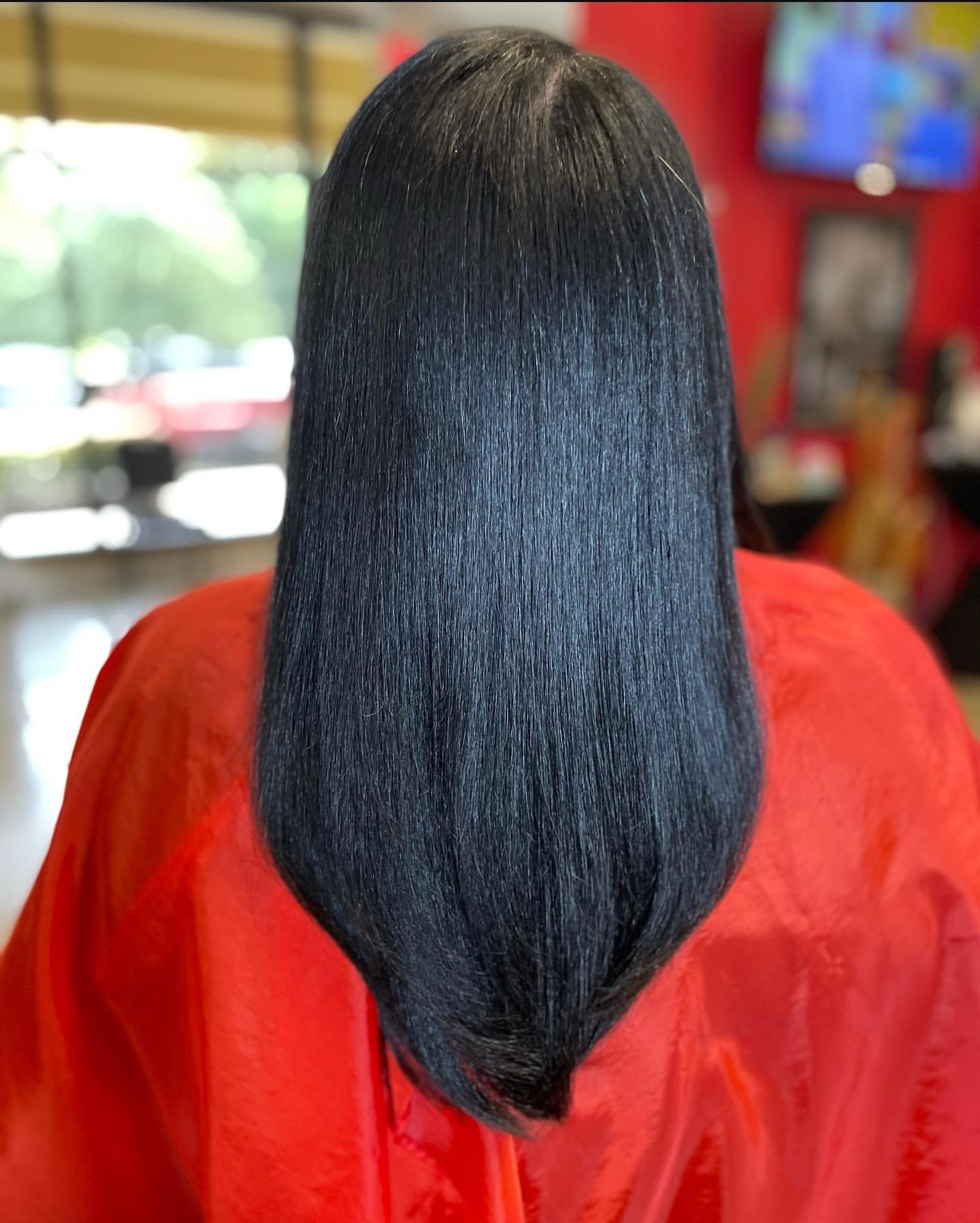 Long, healthy silk-pressed hair styled smooth and glossy on a Blessed Hands client